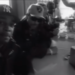 Four men sit at a diner counter as part of Public Enemy's "By the Time I Get to Arizona" Music Video.